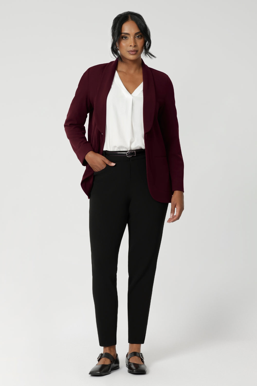 The design features a longline, relaxed fit that creates a sophisticated yet comfortable silhouette. The extended shawl collar adds an elegant touch to the piece, while the button-up front provides a classic, polished finish. Australian made from easy care fabric.