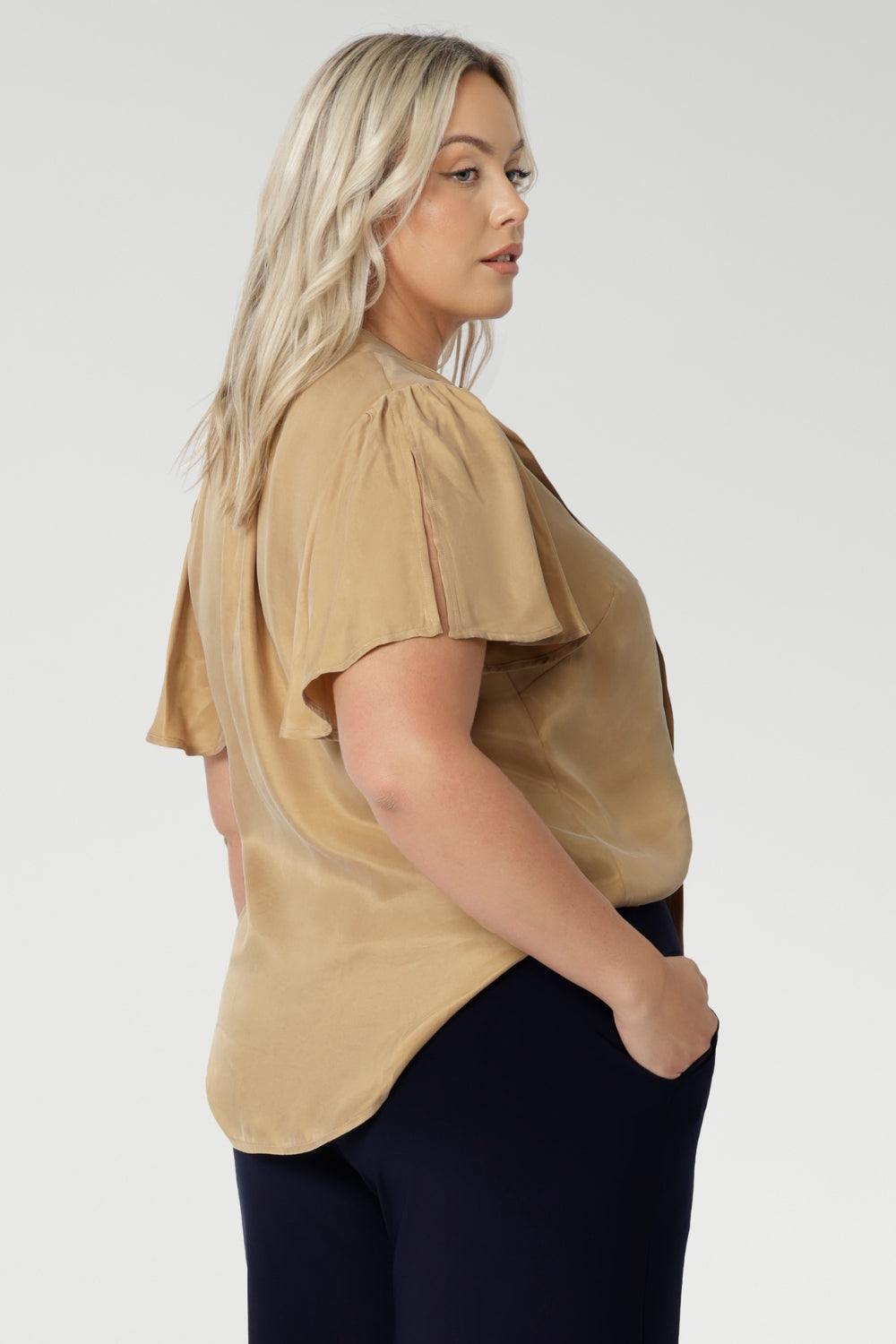 Image shows plus size woman wearing evening blouse, featuring a shirttail hemline. This women's blouse is versatile enough to be tucked into skirts or trousers for a polished look. Available in sizes 8-24 and exclusively online at Leina & Fleur, this shirt is the perfect addition to any wardrobe.