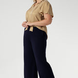 Plus size woman wears semi-fitted design of the Michael Shirt. Tailored yet relaxed feel, this blouse has the right amount of structure without feeling too tight. The V-neckline with delicate neckties adds a touch of feminine elegance, while allowing you to adjust the fit for added comfort and style. The short flutter sleeves, with slits on the shoulders, add a modern, airy feel to the blouse, perfect for this time of year. Available in sizes 8-24.