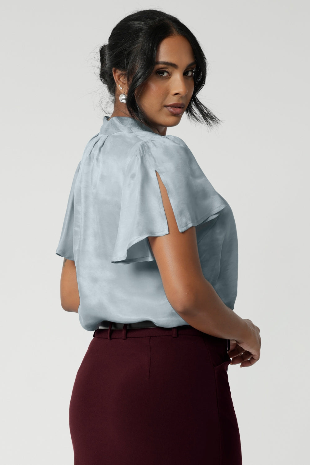 Made from a luxurious soft suede-touch Tencel fabric in a cool, serene Ice Blue colour. This women's blouse drapes beautifully on the body, creating a flattering and luminous effect. Breathable blouse features flutter sleeves with slits and shirttail hem.