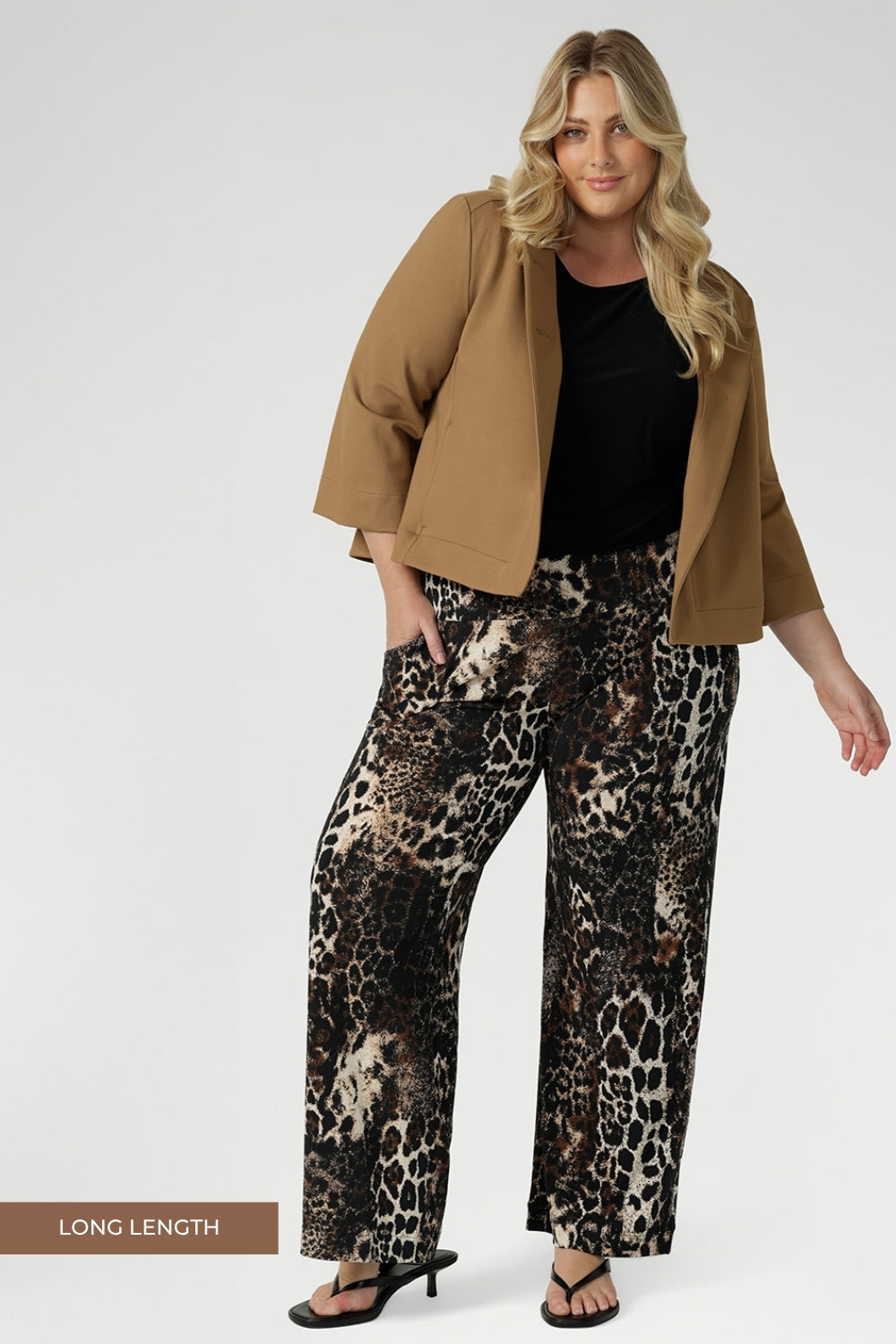 Plus size woman wears her Monroe Pants in Panthera in the long length withblack shirt, layered under a caramel ponte jacket. Creating an everyday stylish look that makes a statement.