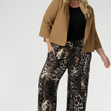 Plus size woman wears her Monroe Pants in Panthera in the long length withblack shirt, layered under a caramel ponte jacket. Creating an everyday stylish look that makes a statement.