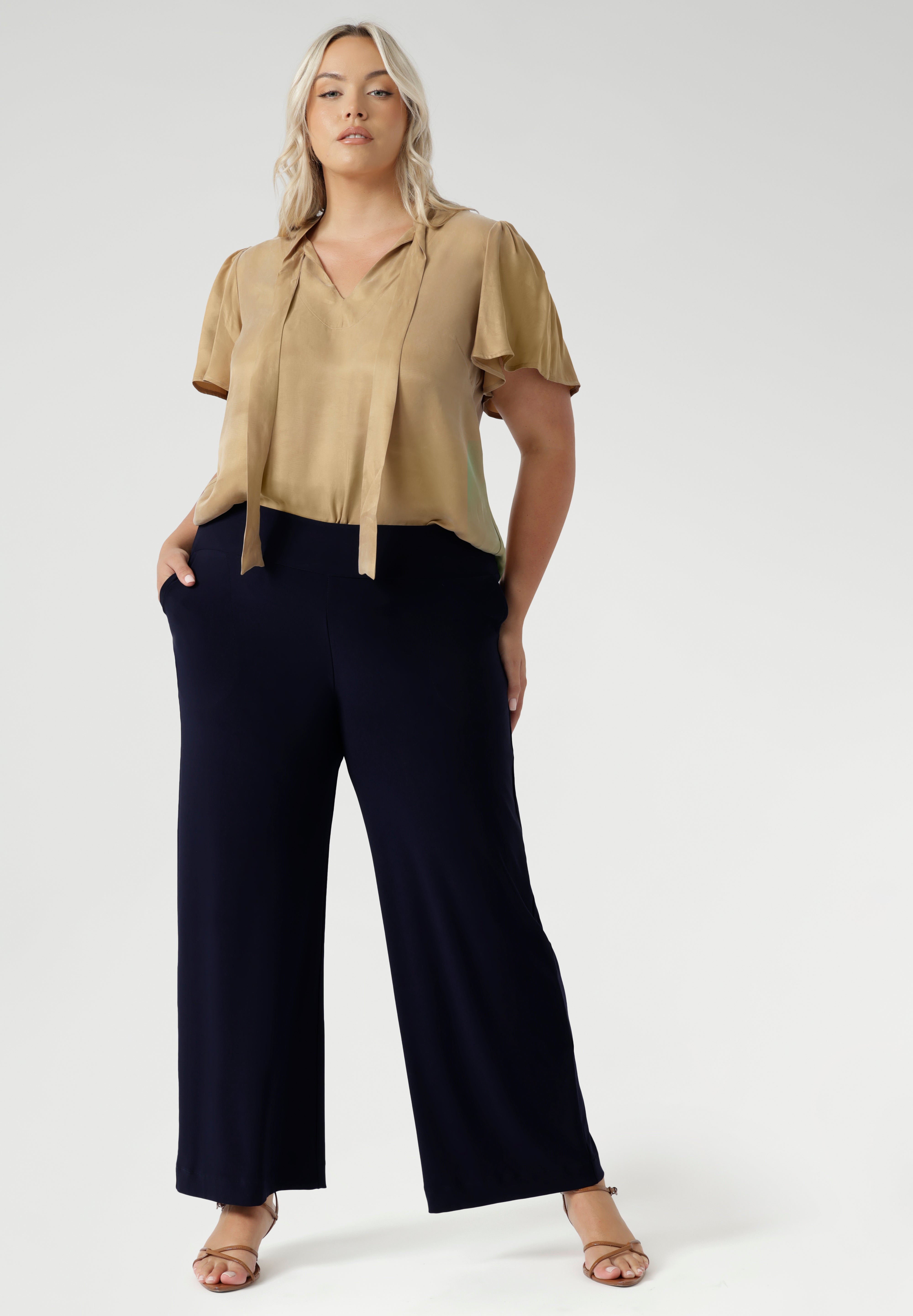 Women's size inclusive work pants. Pictured on a size 18 woman, these comfortable navy corporate pants. Full length navy, straight leg pants with stretch. Shop in sizes 8-24.