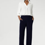 Women's size inclusive work pants. Pictured on a size 10 woman, these comfortable navy corporate pants. Full length navy, straight leg pants with stretch. Shop in sizes 8-24. Over 30s woman wears the Monroe Pants Navy in the long length.