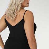 Black slip dress for women is seen on size 18 woman with Vneck back facing. Reversible for multiple styling options. Perfect base layer to wear under dresses or separates for smooth, comfortable coverage & warmth.