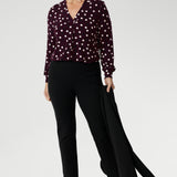 Whether you’re dressing for the office or a day out, the Paeton Top delivers effortless style, comfort, and modern femininity. The Paeton Top in burgundy spot is a standout piece in our luxe separates collection, combining everyday comfort with elevated design. Mature model wears her Paeton Top with black tapered leg pants and matching black work wear jacket.