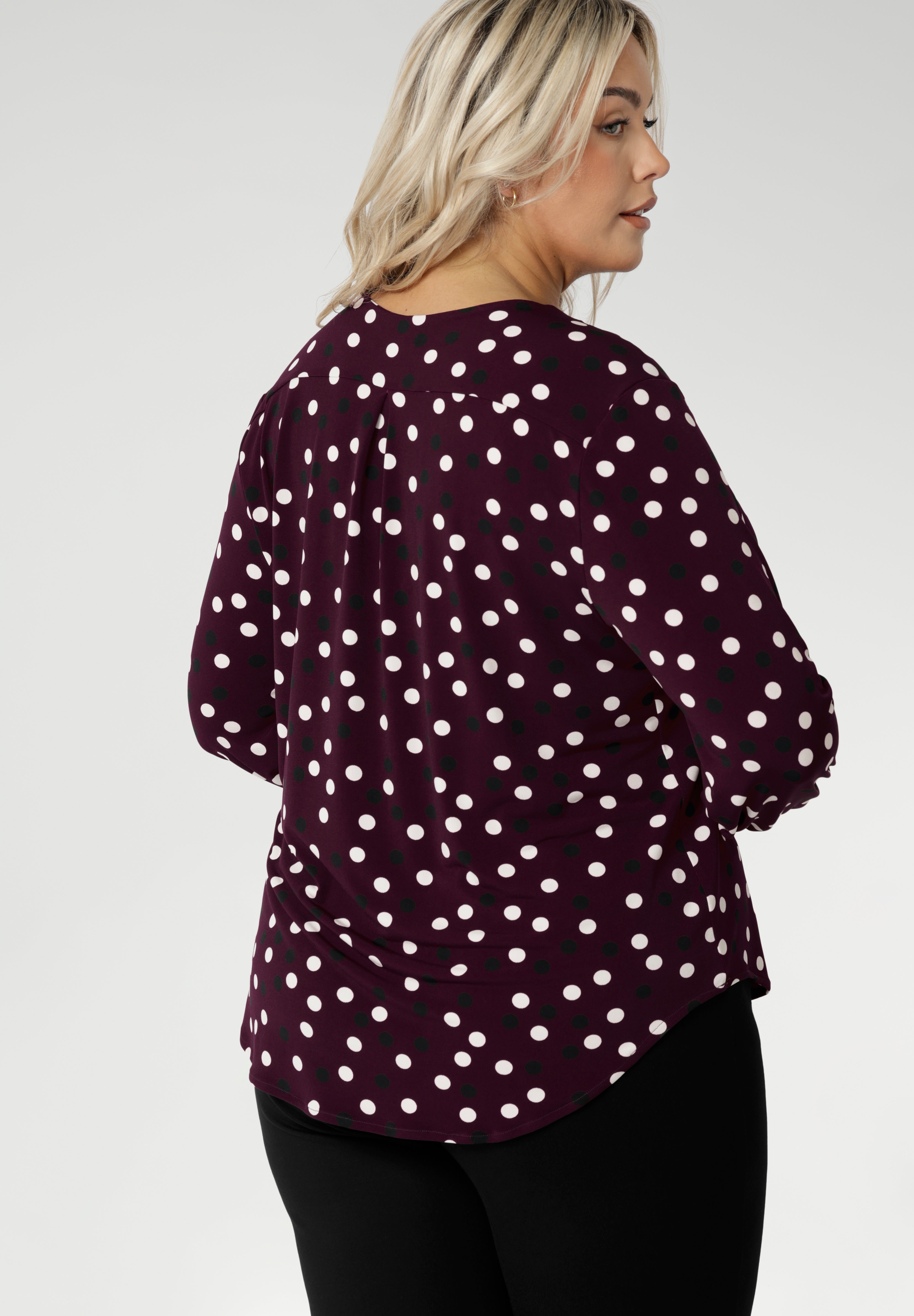 At the back, a shoulder yoke flows into a centre-back tuck, offering subtle detail and a touch of sophistication. The curved shirttail hemline enhances versatility, making it perfect for layering over pants or skirts without the need to tuck in.