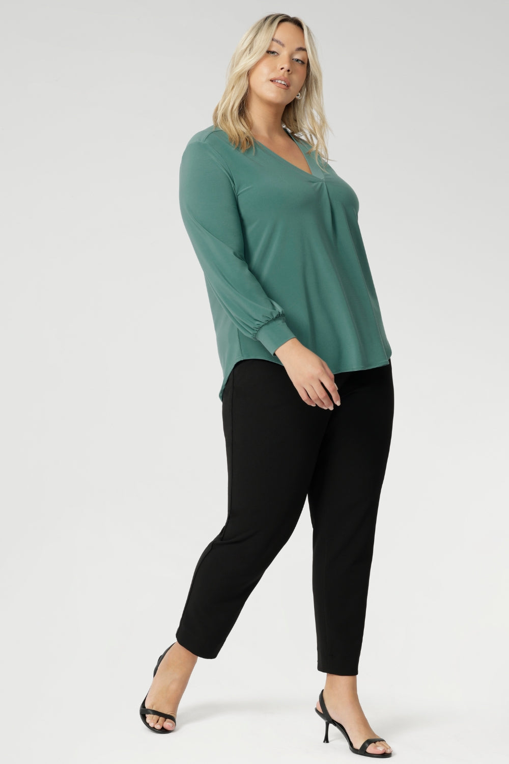 Paeton is ideal for workdays, weekend styling, and effortless winter layering. Available in sizes 8 to 24. Plus size woman wear Paeton Top in Menthol with black tapered leg pants and black kitten heels - Creating a go to work look.
