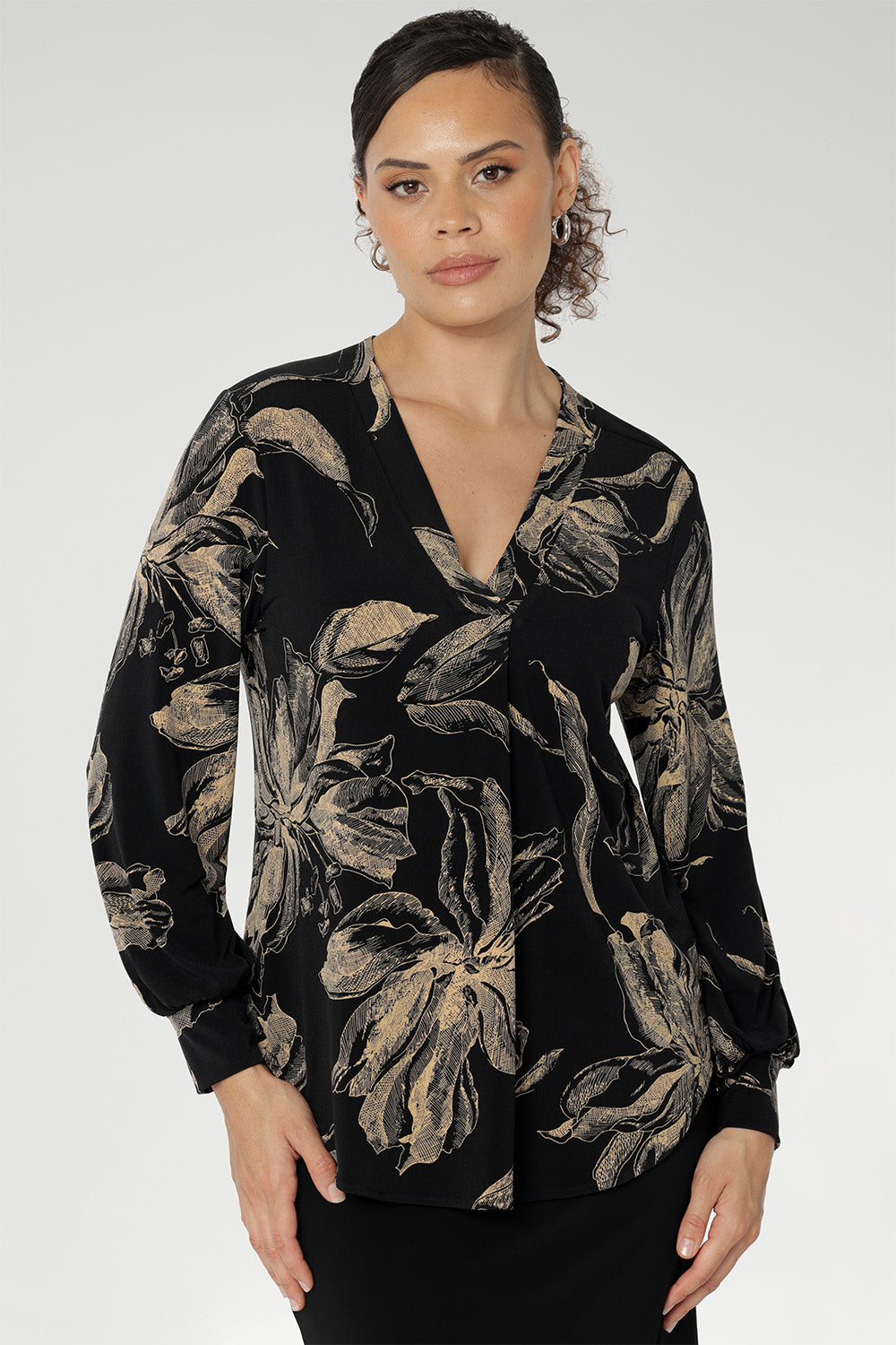 Discover effortless elegance with the Paeton Top, a signature piece from our luxe separates collection. Expertly crafted in Australia from premium black dry-touch jersey, this top combines soft stretch with a flattering, relaxed fit that drapes gracefully on the body. The deep, inky floral print in a rich coffee hue brings a moody seasonal edge, while refined design details—such as the V-neckline with a tailored front tuck, long sleeves with cuffs, a structured shoulder yoke, and a curved shirttail hem.