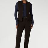 Designed for comfort and versatility, it features a flattering close-to-body fit that moves with you, thanks to its generous stretch and breathable finish. Size 10 woman wears her wool top tucked into her cocoa coloured tapered leg pants, and matching vest.