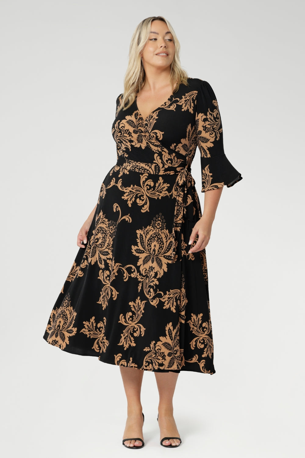 Size 18 woman wears her Portia Dress with black kitten heels. Printed jersey dresses proudly made in Australia and available in sizes 8 to 24. Made with easy care fabric that provides stretch and comfort.
