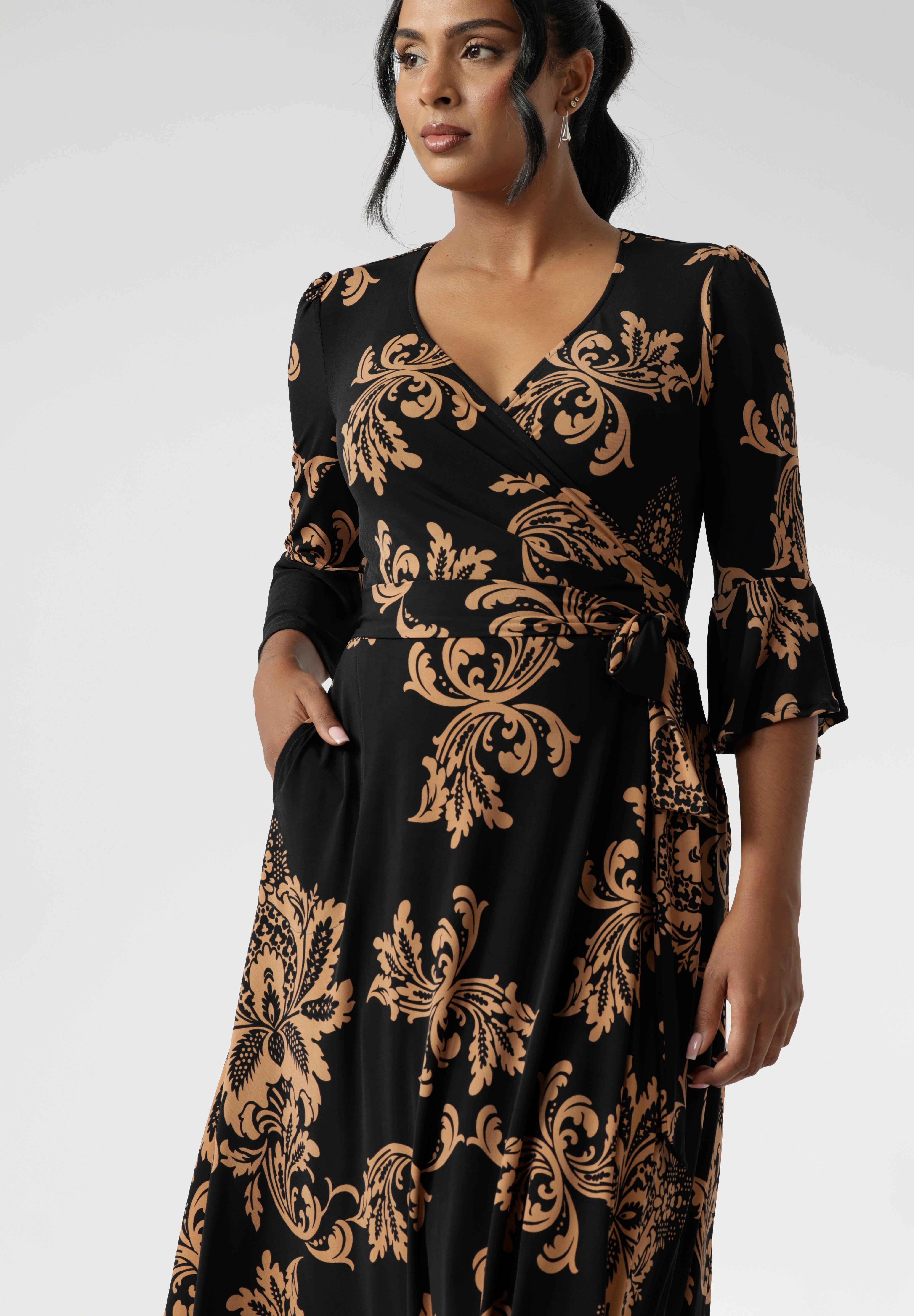 Portia features our signature fluted 3/4 sleeves for a romantic touch, along with a gathered detail at the sleeve head for added charm. Women's Wrap dress has floral design print on a black base. Available in size 8-24.