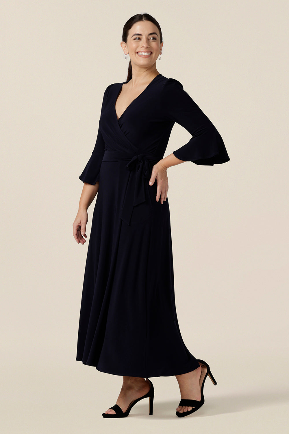Shown for petite height women, this navy blue wrap dress is perfect for elegant evening and occasion wear. This is a cocktail dress with 3/4 sleeves and a full midi-length skirt. Made in Australia, shop wrap dresses in sizes 8 to 24 at Leina & Fleur.