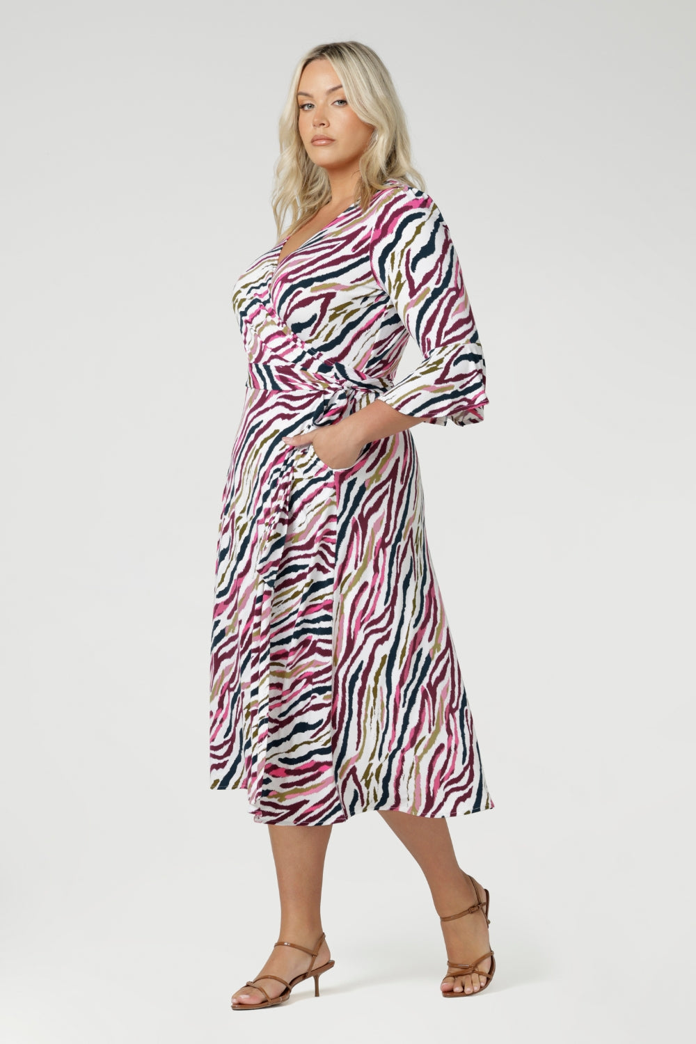 his versatile wrap dress features a functioning wrap style with waist ties for an adjustable fit. The double-layer back bodice provides added structure, while the 3/4 length fluted sleeves below the elbow bring a romantic, feminine flair.