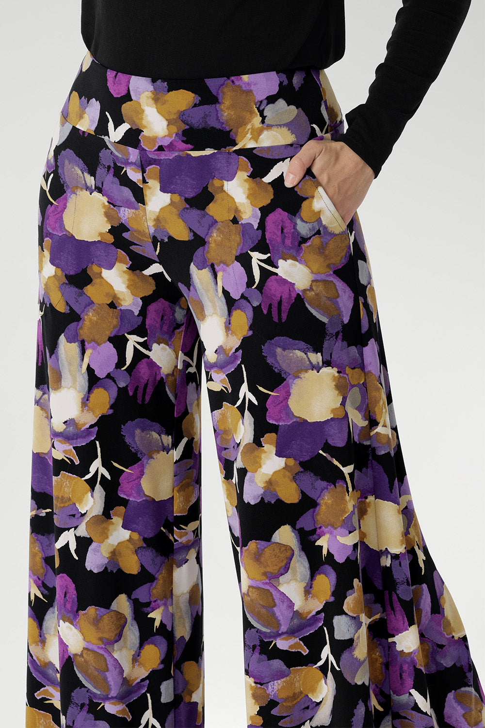 The vibrant painterly-style floral print in rich purples and soft yellow hues adds an artistic edge, making these pants perfect for travel, special occasions, or simply turning heads wherever you go.