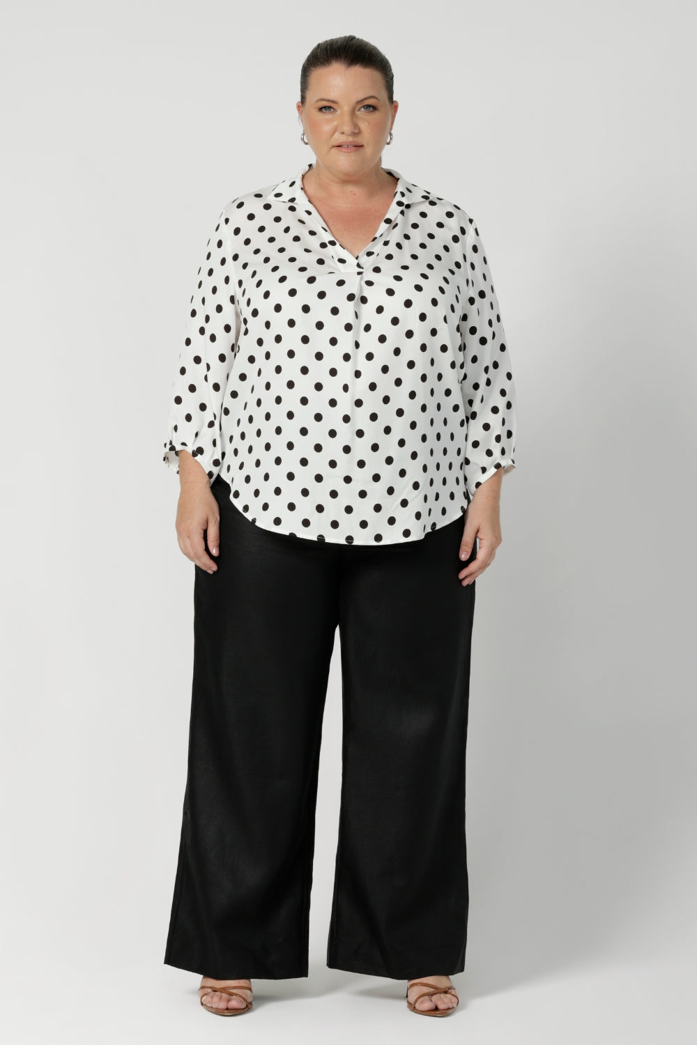 Proudly made in Australia, this pant is available in sizes 8-24, offering an inclusive fit for all women. Black work wear pants are styled with black spotted white blouse and brown small heel. Offering a smart casual office chic look.