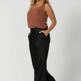 Practical side pockets provide convenient storage and add a touch of casual charm to these black workwear pants. Designed to support and enhance the style of a woman on the go. Sizes 8-24 available.
