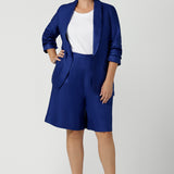 Women wears the Houston Blazer in Cobalt linen size 12. Styled back with a matching Cobalt Linen Blazer with a button front and patch pockets. Made in Australia for women size 8 to 24.