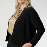 Size 18 woman wears black Jacardi, which is part jacket, part cardigan. This soft touch jacket is a transeasonal cover up. Featuring V-neckline, long sleeves and front buttons. This casual black jacket is made from stretchy and comfortable jersey fabric. Easy care workwear jacket available in sizes 8-24.