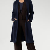 The Sorel Trench Coat is expertly tailored with a modern, sophisticated silhouette that elevates any wardrobe. Mature aged model wears Sorel Trenchcoat in Midnight over fluid suiting for a comfortable and warm travel outfit.