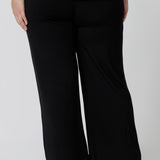 Back view of comfortable loungewear pants in black bamboo jersey. A size 18 woman wears straight wide leg black bamboo lounge pants with a black bamboo slouchy tee top. Thermo-regulating and breathable this is a great pyjama set for night sweats and hot flushes. Shop plus size lounge and sleepwear online at L&F Australia.