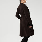 Petite height model wears the Sorel Trench Coat over Paxton Pants & Bryn Top in black for a warmer layer over work wear outfit. The buggy lining at the back ensures added comfort, while the waist seam at the back provides a flattering shape. With belt loops and a fabric waist tie, this versatile trench coat is available in sizes 8-24 and is proudly made in Australia.