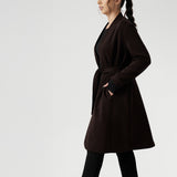Petite height model wears the Sorel Trench Coat over Paxton Pants & Bryn Top in black for a warmer layer over work wear outfit. The buggy lining at the back ensures added comfort, while the waist seam at the back provides a flattering shape. With belt loops and a fabric waist tie, this versatile trench coat is available in sizes 8-24 and is proudly made in Australia.