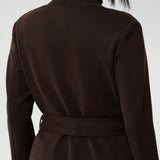 The Sorel Trench Coat is expertly tailored with a modern, sophisticated silhouette that elevates any wardrobe. Size 10 woman wears winter coat crafted from a luxurious winter-weight Modal fabric over long length black pants, black turtle neck, and high heel boots for an elevated workwear look.