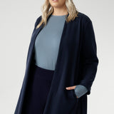 Its grown-on neckline eliminates the need for a collar, offering a sleek, contemporary look. The buggy lining at the back ensures added comfort, while the waist seam at the back provides a flattering shape. With belt loops and a fabric waist tie, this versatile trench coat is available in sizes 8-24 and is proudly made in Australia.
