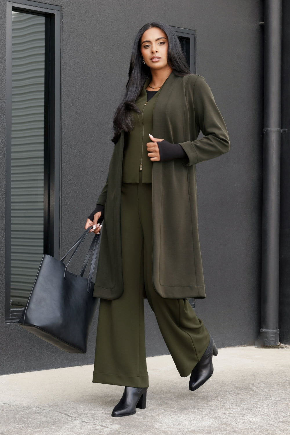 The Sorel Trench Coat is expertly tailored with a modern, sophisticated silhouette that elevates any wardrobe. Size 10 model wears winter Trenchcoat in Dark Olive over a olive coloured suiting, creating an elevated workwear look.