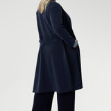 The coat features tailored panels at the front with concealed pockets seamlessly integrated into the seams, along with two-piece long sleeves for a refined fit.