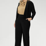Size 18 woman wears black Jacardi, which is part jacket, part cardigan. This soft touch jacket is a transeasonal cover up. Featuring V-neckline, long sleeves and front buttons. This casual black jacket is made from stretchy and comfortable jersey fabric. Easy care workwear jacket available in sizes 8-24.