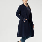 Petite height model wears the Sorel Trench Coat over Paxton Pants & Bryn Top in Navy for a warmer layer over casual workwear look. The buggy lining at the back ensures added comfort, while the waist seam at the back provides a flattering shape. With belt loops and a fabric waist tie, this versatile trench coat is available in sizes 8-24 and is proudly made in Australia.