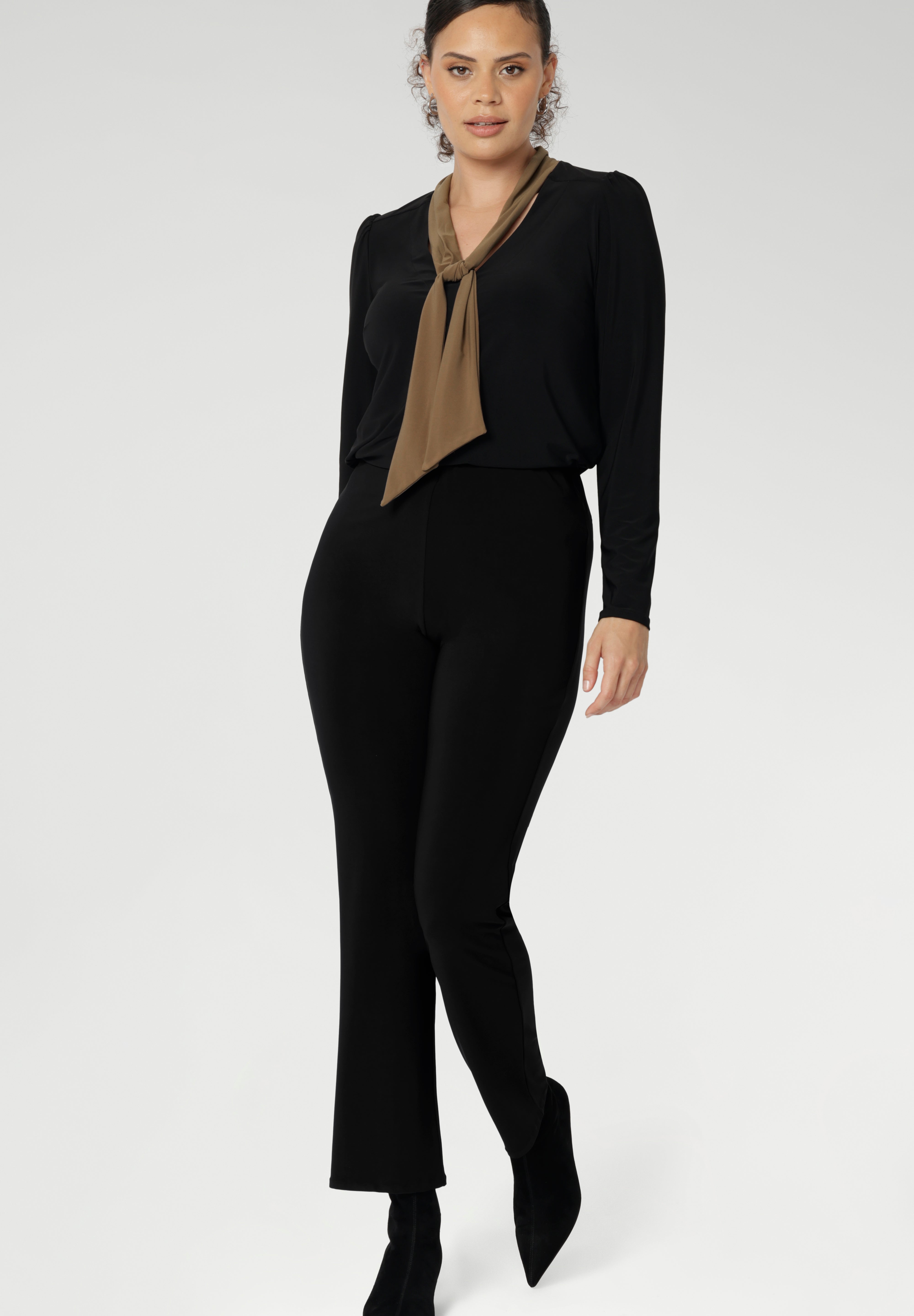 The Thom Top is available in an inclusive size range from 8 to 24, delivering effortless sophistication and comfort for both workwear and special occasions. Size 10 woman wears her Thom Top with black straight leg pants.