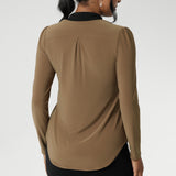 Full-length sleeves with gentle gathers at the shoulders add a touch of femininity, while the shoulder yoke and tailored tuck at the back create subtle shape without feeling structured. Finished with a shirttail hemline, it’s a top that layers easily under suiting and transitions seamlessly from desk to dinner.