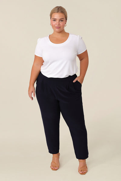 Great pants for travelling, these dropped crotch, trousers with cropped, tapered legs are show for petite height women. Worn with a white bamboo jersey, short sleeve top, these stretchy navy jersey, pull-on trousers are comfortable travel pants that wear well as weekend and casual pants too.
