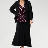 Our mature-aged model wears this elegant women’s workwear top, designed with a flattering peplum silhouette and a dipped back hem for added coverage and a feminine finish. Proudly Australian made from a dry-touch jersey fabric, this style is available in sizes 8–24. Style with Merit Blazer in Black & Asher Skirt in Black.