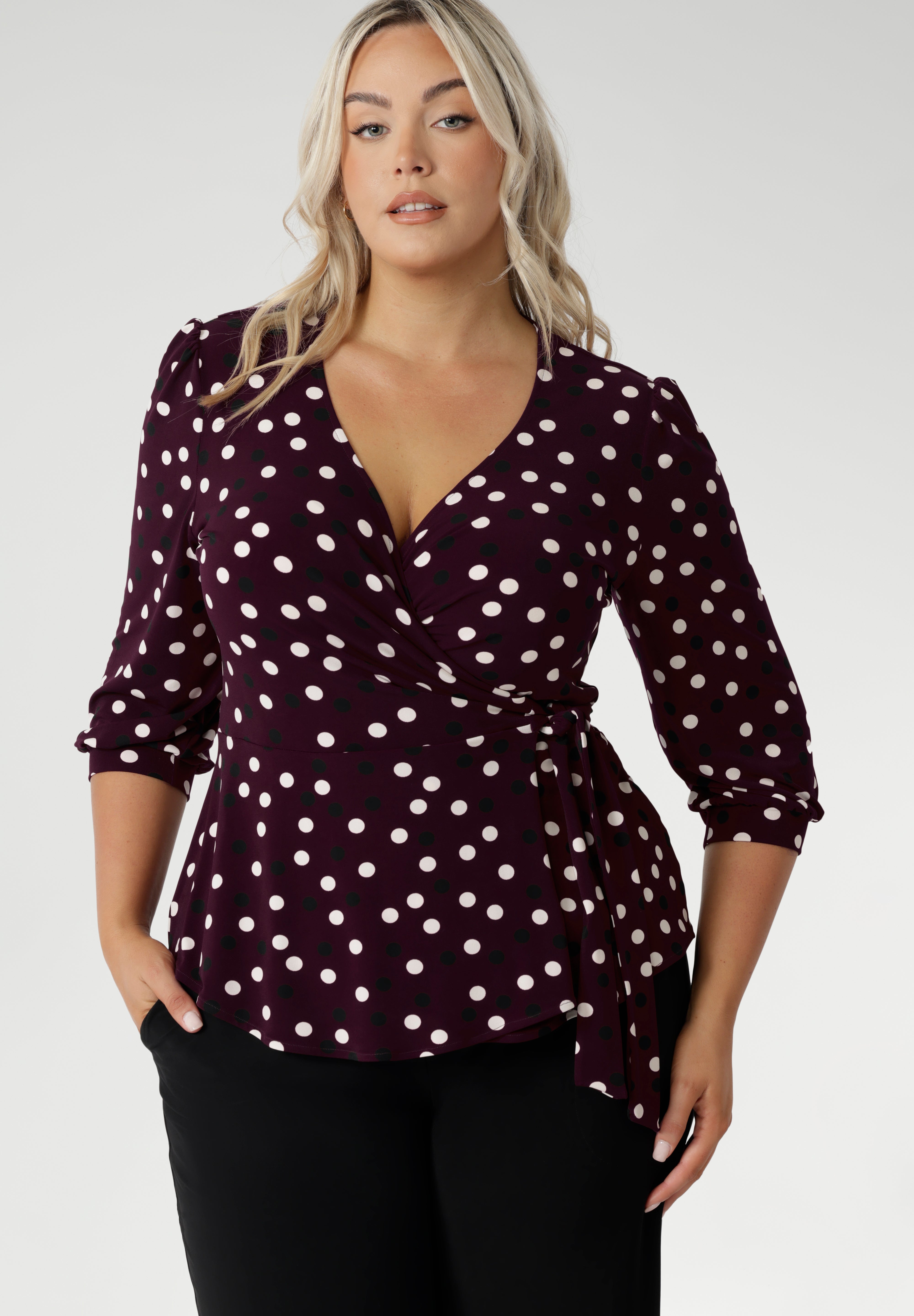 The Tristan wrap top is thoughtfu lly designed for both comfort and style. Featuring a flattering peplum silhouette, its hemline dips gracefully at the back, offering extra coverage and a feminine touch. Crafted from a dry touch jersey base with a timeless spotted design. Available in sizes 8-24.