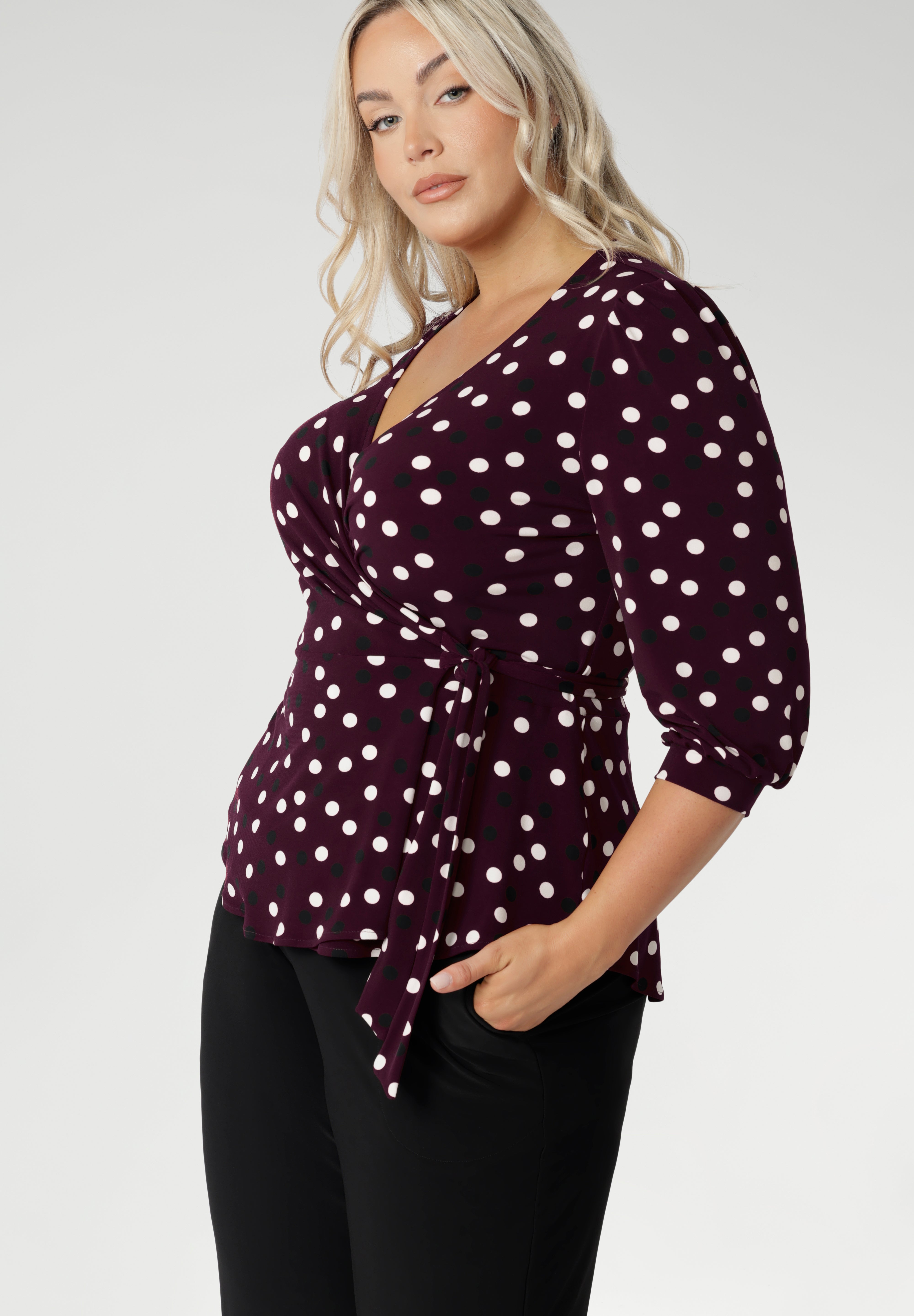The Tristan wrap top is thoughtfu lly designed for both comfort and style. Featuring a flattering peplum silhouette, its hemline dips gracefully at the back, offering extra coverage and a feminine touch. Crafted from a dry touch jersey base with a timeless spotted design. Available in sizes 8-24.