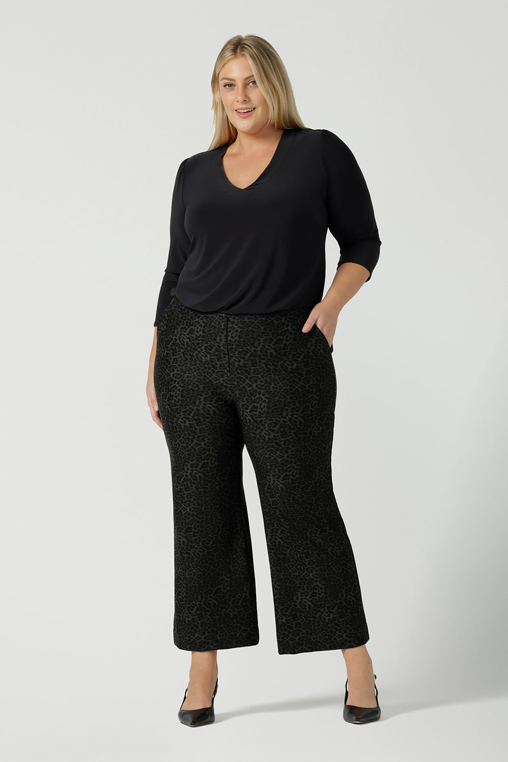 A size 18 woman wears Grey Leopard printed Ponte Troy Pants. A kick flare pant in a fashionable on trend leopard print paired back with a Vida top in Charcoal. Made in Australia for women size 8 - 24.