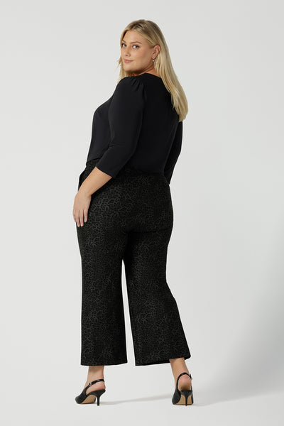 Back view of a size 18 woman wears Grey Leopard printed Ponte Troy Pants. A kick flare pant in a fashionable on trend leopard print paired back with a Vida top in Charcoal. Made in Australia for women size 8 - 24.