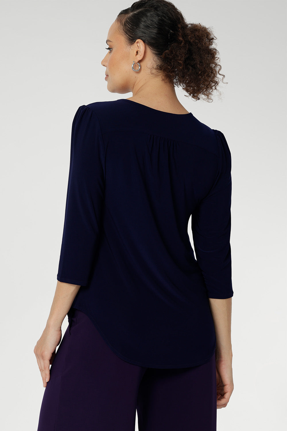 Styled with fluid suiting, the Vida Top creates a polished, professional look while remaining versatile enough for casual wear. Shown from the back, the clean lines and refined silhouette highlight its easy fit and timeless appeal. Proudly made in Australia and available in inclusive sizes 8 to 24.
