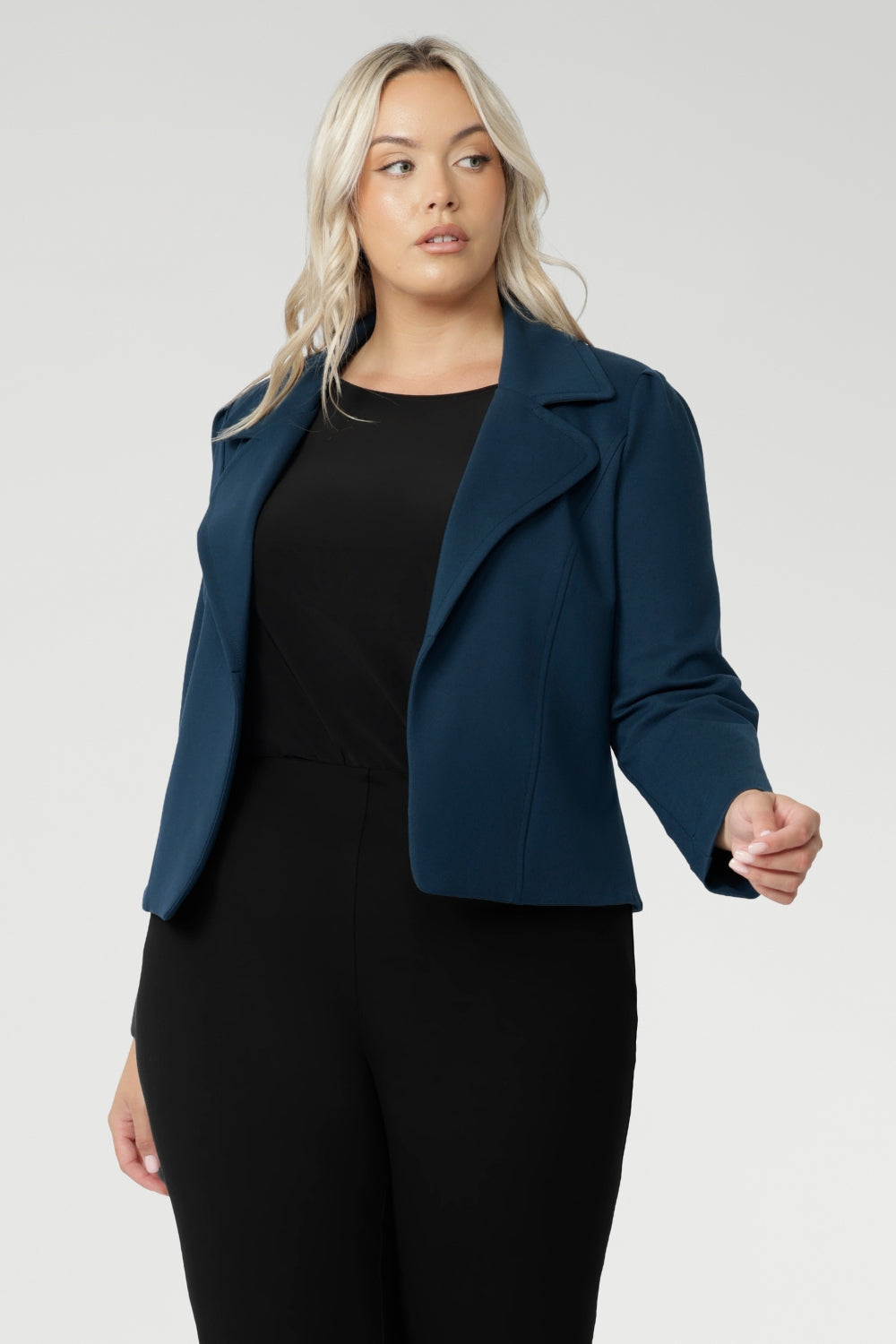 Plus size woman wears knit top under her Garcia Jacket in Petrol. Designed for comfort and versatility, it features a flattering close-to-body fit that moves with you, thanks to its generous stretch and breathable finish. Black knit top has thumbholes that can be used or tucked away for versatility in styling and extra warmth. Available in size 8-24.
