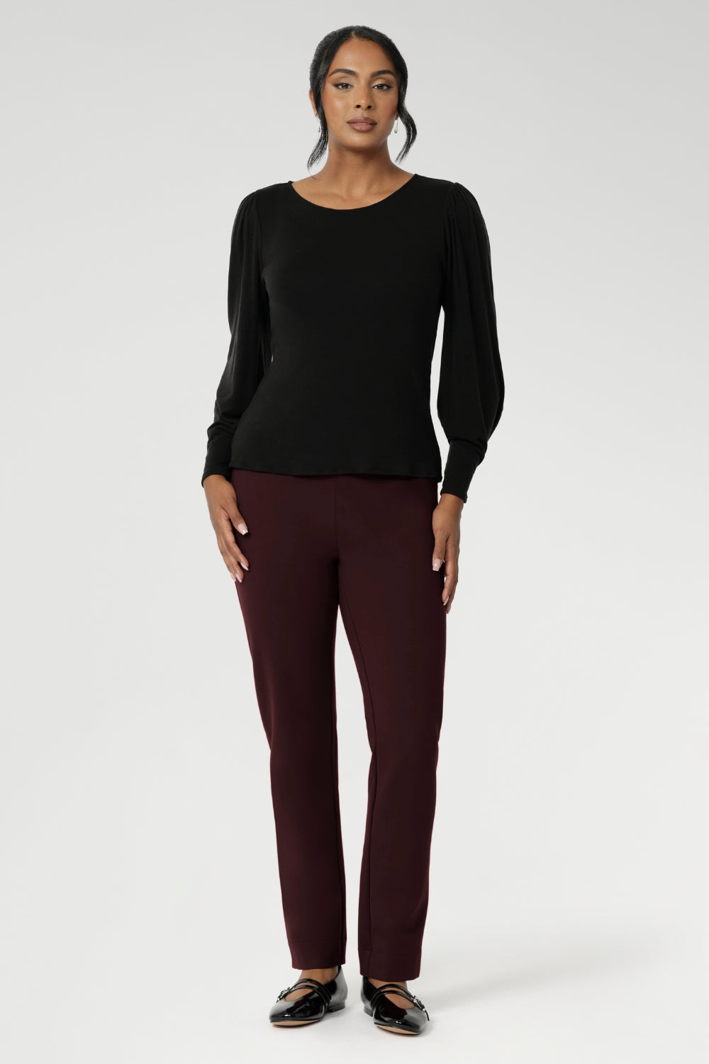 The boat neckline frames the collarbone with subtle sophistication, while tailored bust darts and a close-to-body shape enhance the fit without feeling restrictive. Crafted with attention to detail, the full-length sleeves feature gentle gathers at the shoulder and a wrist dart, adding soft volume and movement—ideal for styling under outerwear without bulk.