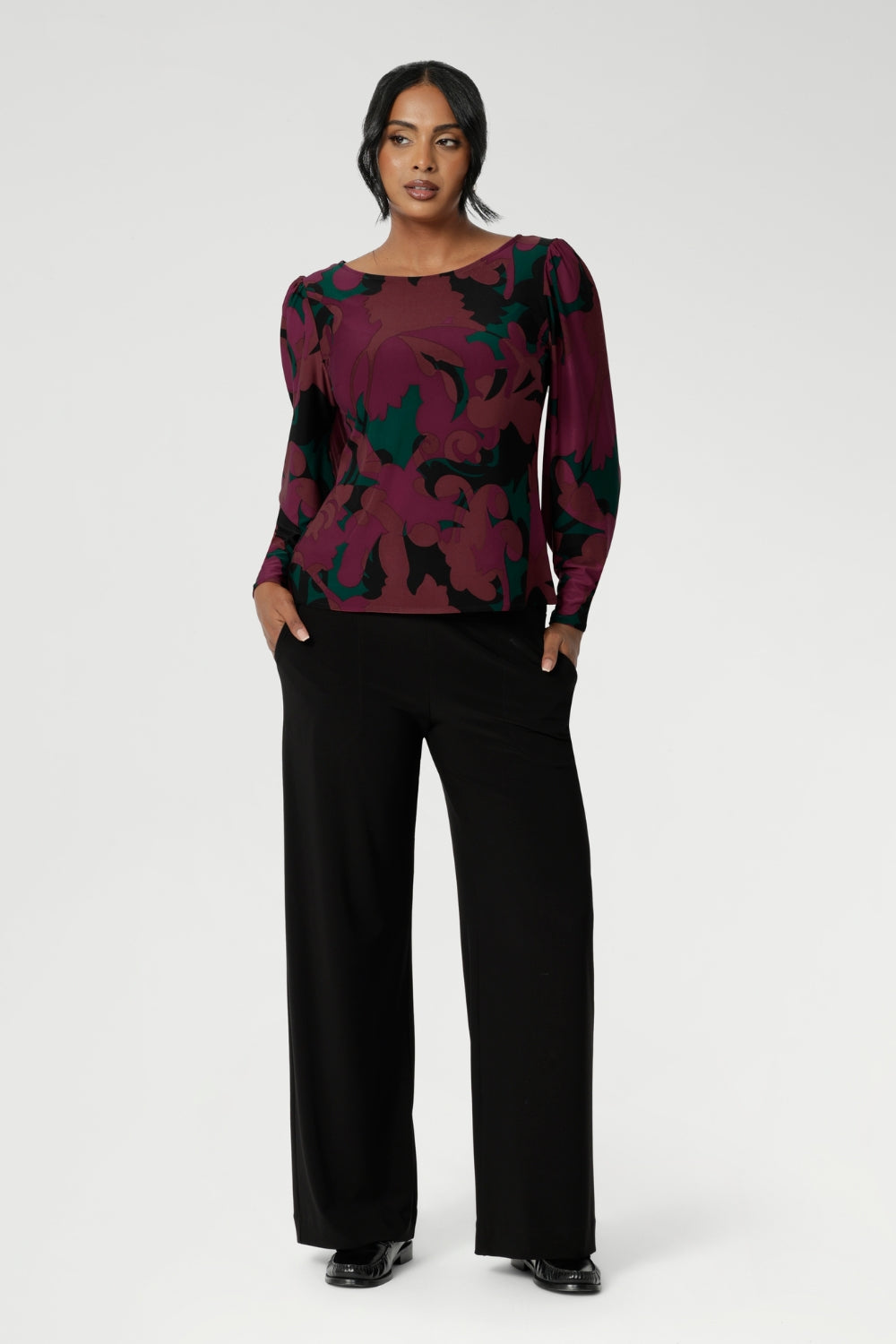 The Fuchsia Maya print is on a soft touch jersey fabric with print details in deep fuchsia, green, terracotta and black. The fabric has soft stretch. Size 10 model wears her long sleeved top with black workwear pants and loafers. Available in sizes 8-24.