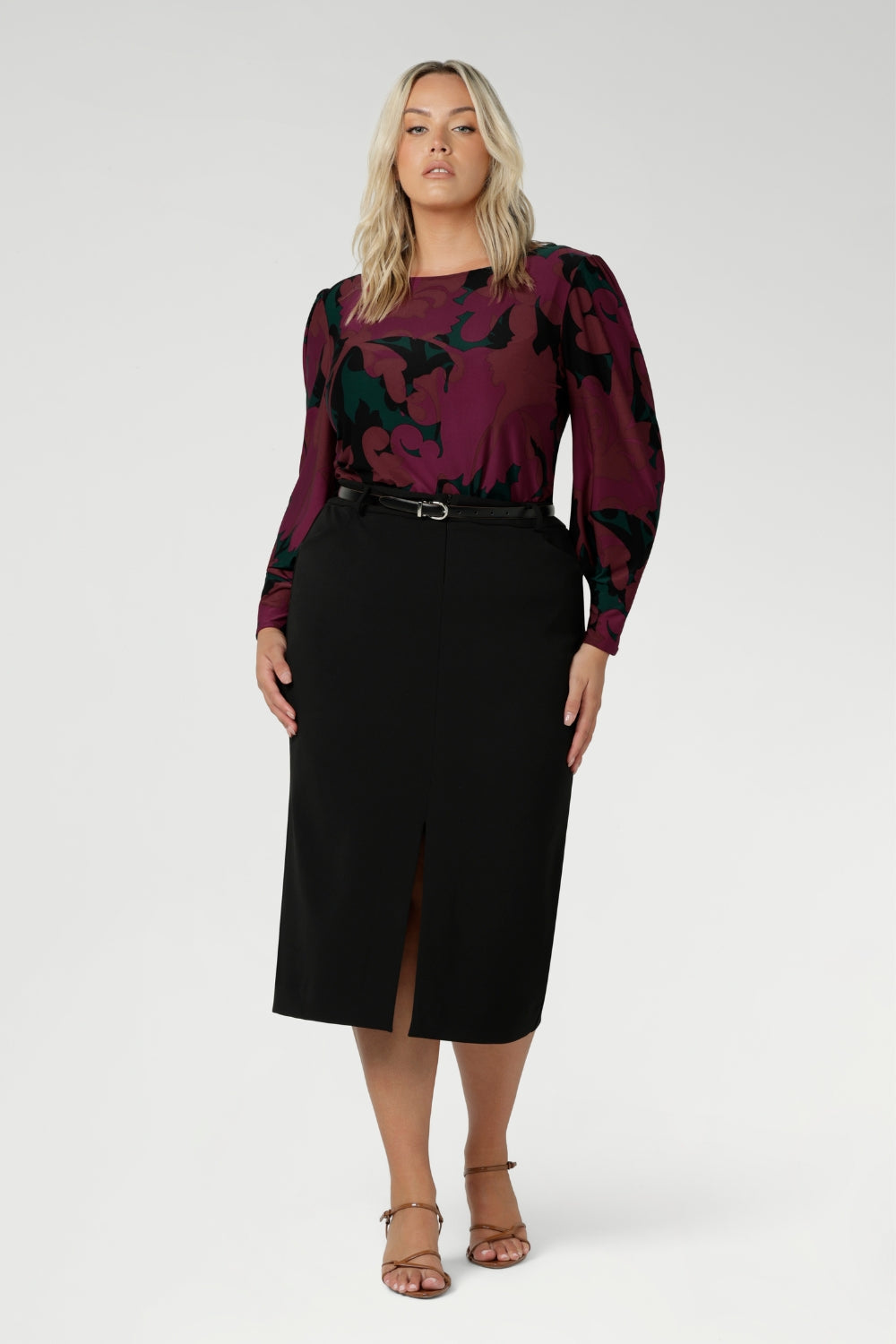 The Fuchsia Maya print is on a soft touch jersey fabric with print details in deep fuchsia, green, terracotta and black. The fabric has soft stretch. Plus size model wears her long sleeved top tucked into black workwear skirt. Available in sizes 8-24.