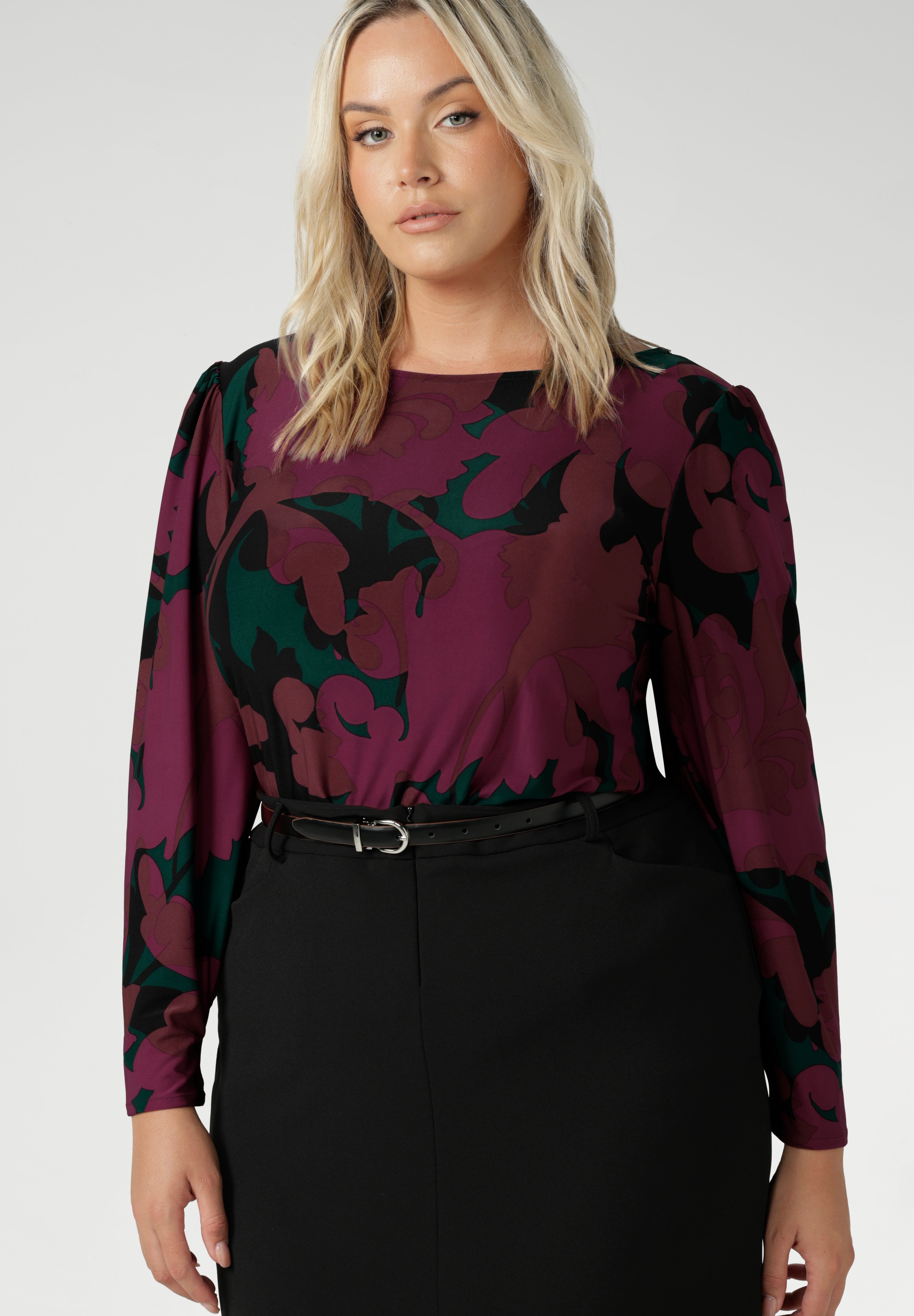 The Fuchsia Maya print is on a soft touch jersey fabric with print details in deep fuchsia, green, terracotta and black. The fabric has soft stretch. Plus size model wears her long sleeved top tucked into black workwear skirt. Available in sizes 8-24.