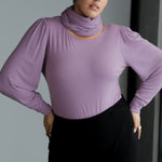Zara knit top in soft lilac brings a fresh, elegant tone to your autumn and winter wardrobe. Designed for both style and comfort, it features a flattering boat neckline and full-length bellow sleeves with delicate gathers at the shoulders and refined darts at the wrists, creating subtle volume that layers beautifully under coats and jackets.