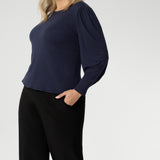 Feminine cut knit top features a boat neckline and full-length bellow sleeves with soft gathers at the shoulders and tailored darts at the wrists, adding gentle volume without the bulk. Subtle shaping through the body and bust darts create a flattering, close-to-body fit that moves easily from work to weekend. Available in sizes 8-24.