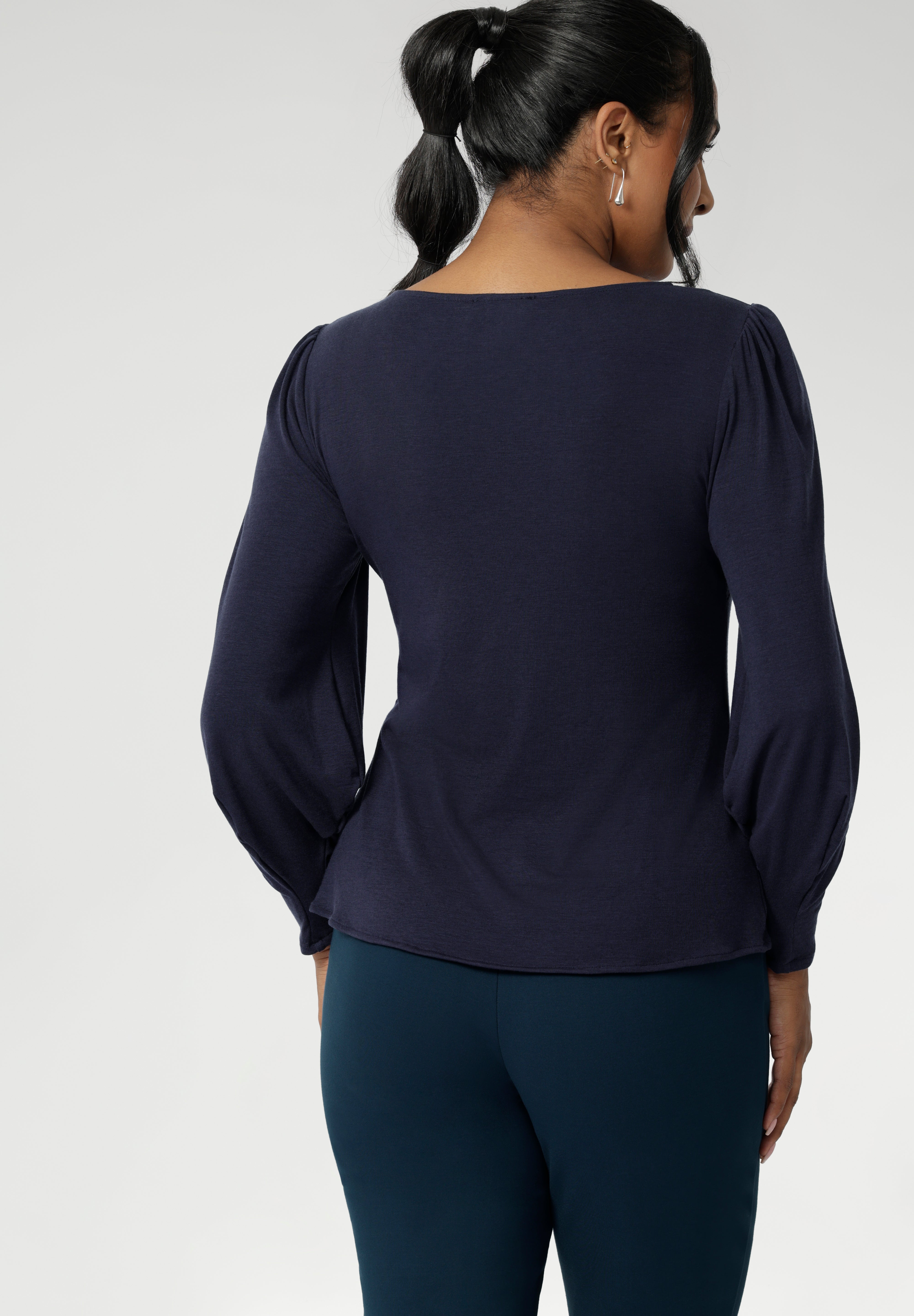 Feminine cut knit top features a boat neckline and full-length bellow sleeves with soft gathers at the shoulders and tailored darts at the wrists, adding gentle volume without the bulk. Subtle shaping through the body and bust darts create a flattering, close-to-body fit that moves easily from work to weekend. Available in sizes 8-24.